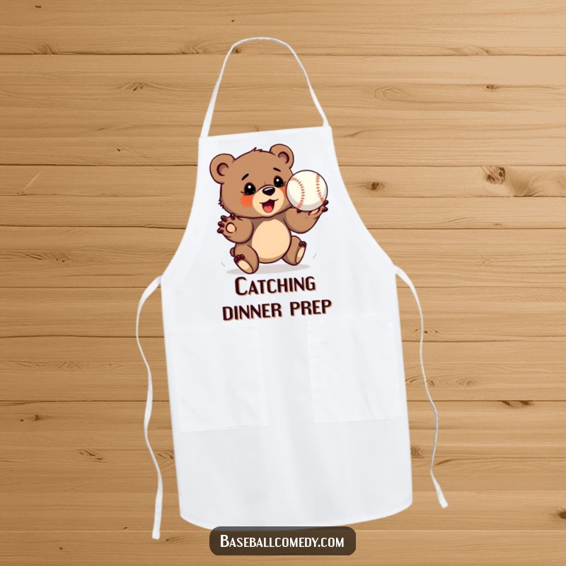 Funny bear cub apron, determinedly catching a baseball with outstretched paws, humorous kitchen accessory.