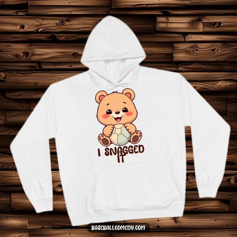 Funny hoodie depicting a smiling bear skillfully catching a ball with its paws, perfect for cozy, humorous wear.